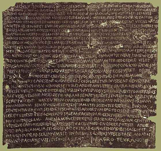 A rectangular bronze tablet densely inscribed with Latin text, its surface worn and pitted with age.