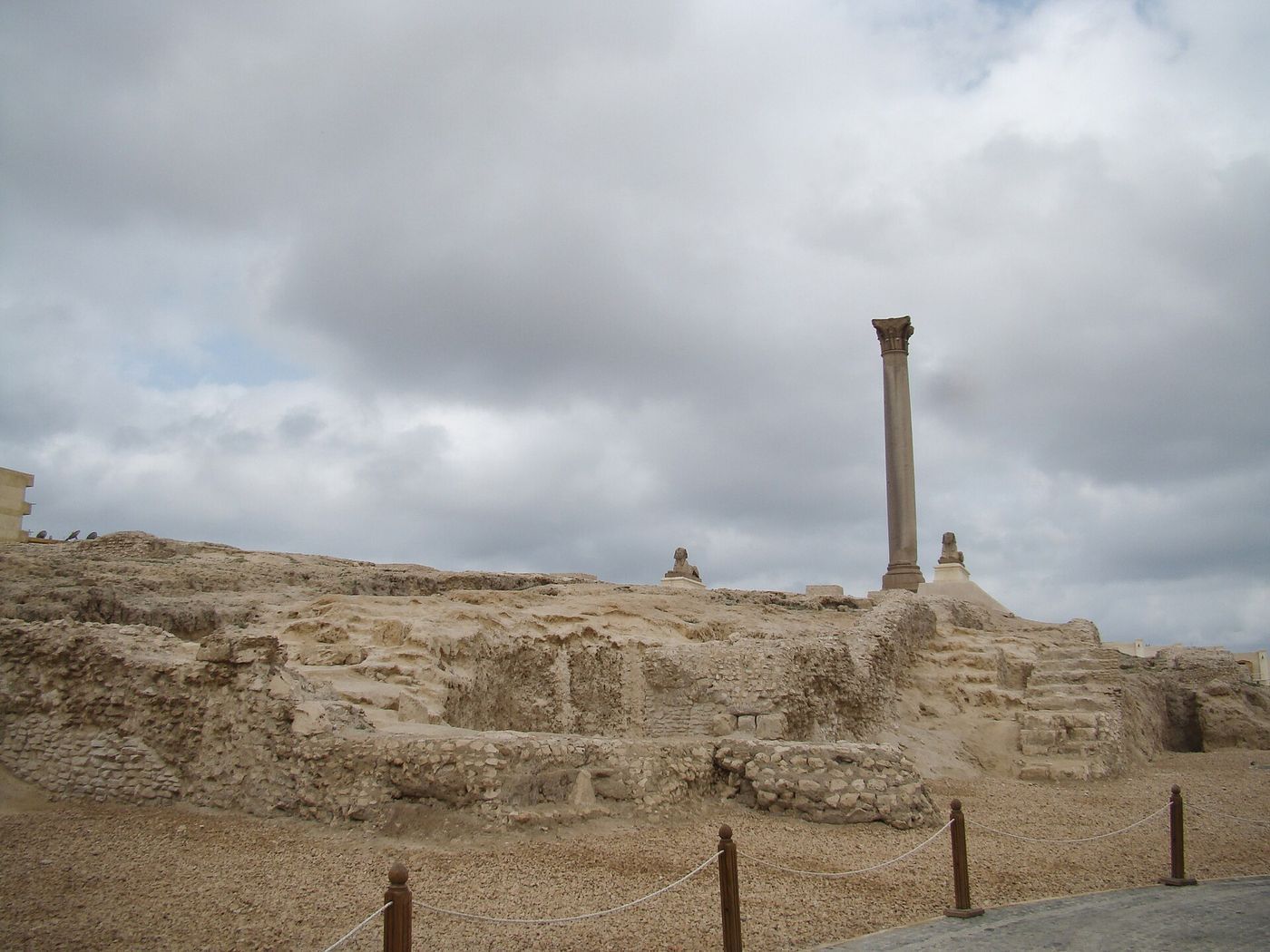 Ruined stone foundations and a tall standing column at the Serapeum site in Alexandria.