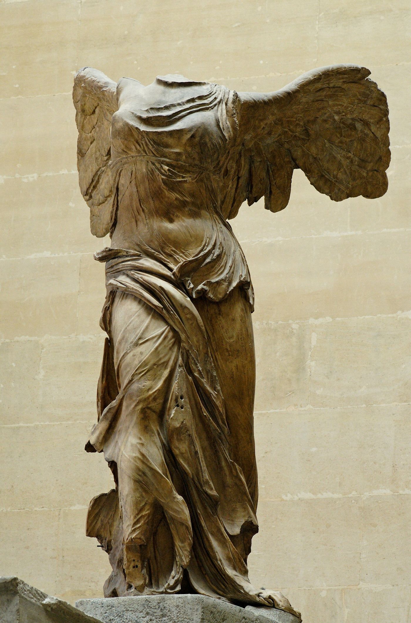 A headless, armless marble statue of a winged woman in wind-blown drapery, standing on the prow of a ship.